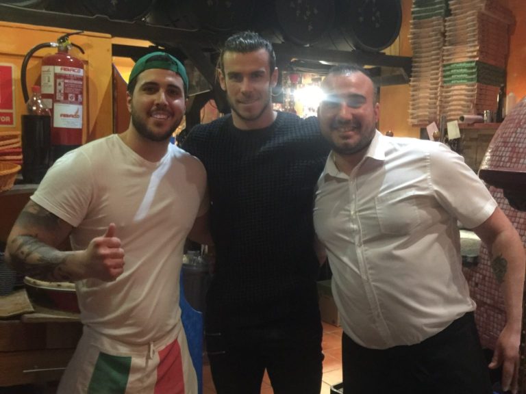 Tres personas comparten una fotografía junto al horno de Bella Napoli