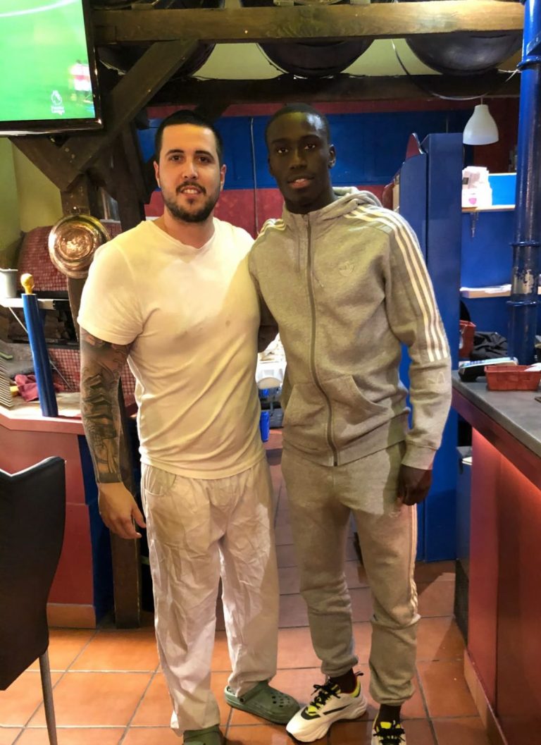 Dos personas posan junto a la cocina de Bella Napoli