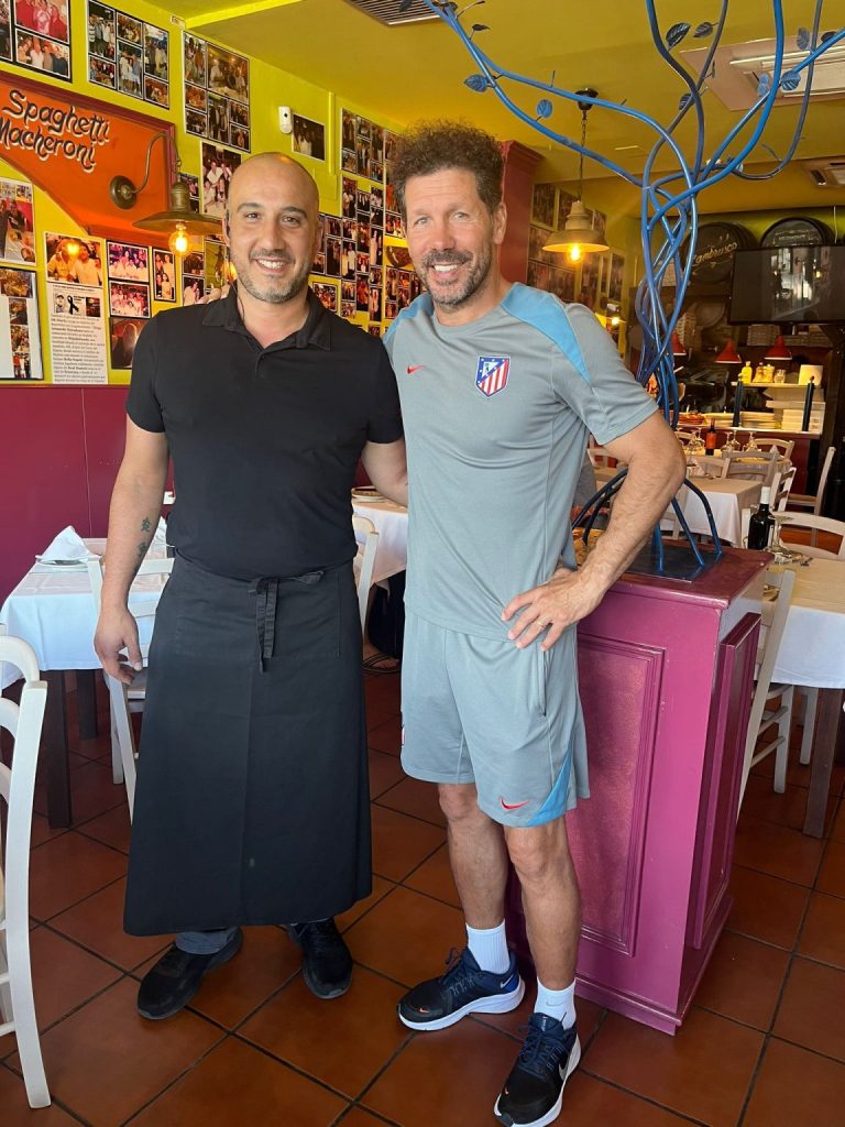 Dos personas posan junto a las mesas de Bella Napoli