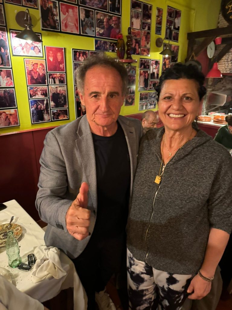 Dos personas comparten una fotografía junto a las mesas de Bella Napoli
