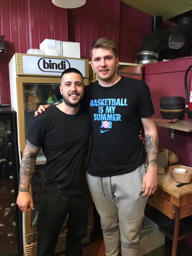 Dos personas comparten una fotografía en el interior de Bella Napoli